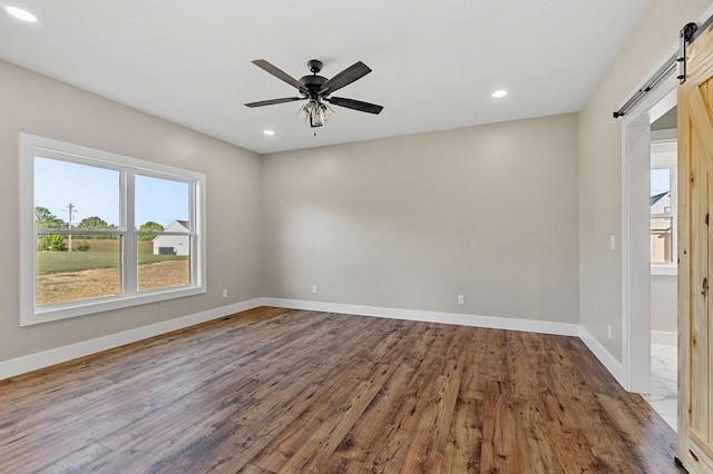2717 Autumn Woods Trl, Cookeville, TN 38501 - empty room with a barn door, wood finished floors, baseboards, ceiling fan, and recessed lighting