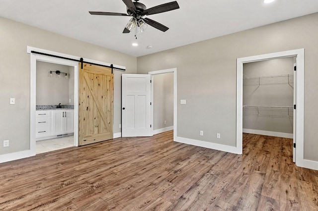 2717 Autumn Woods Trl, Cookeville, TN 38501 - unfurnished bedroom with a barn door, light wood-style floors, baseboards, a spacious closet, and recessed lighting