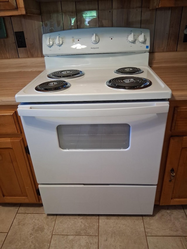 615 Lemont And Yates Mountain Rd, Spencer, TN 38585 - kitchen with white electric range, light tile patterned floors, and brown cabinets