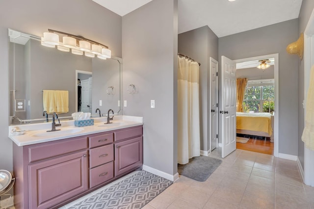 ensuite bathroom featuring tile patterned floors, a ceiling fan, and a sink