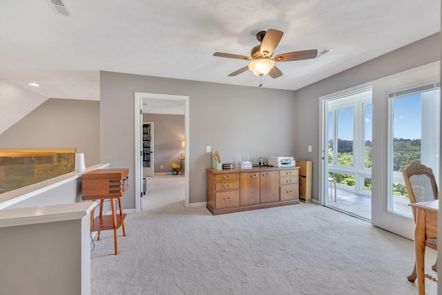 interior space with baseboards, visible vents, ceiling fan, and light colored carpet