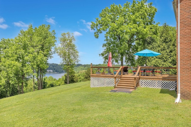 view of yard with a deck with water view