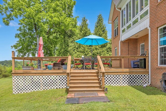 wooden deck with a lawn and outdoor dining space