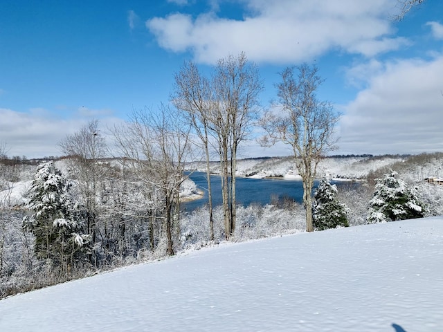 snowy yard featuring a water view
