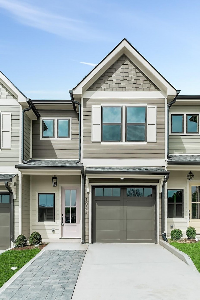 townhome / multi-family property featuring concrete driveway and an attached garage