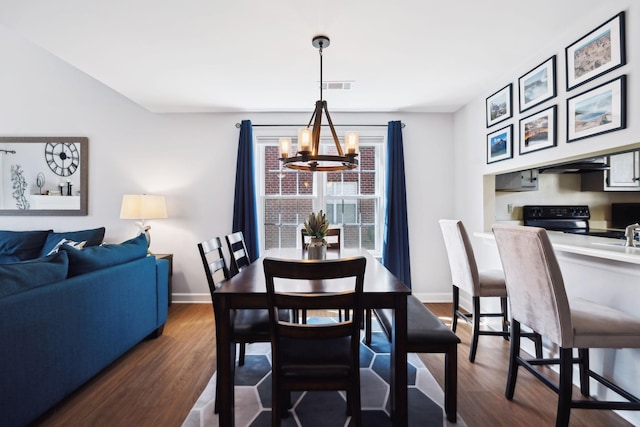 dining space with visible vents, a notable chandelier, dark wood finished floors, and baseboards