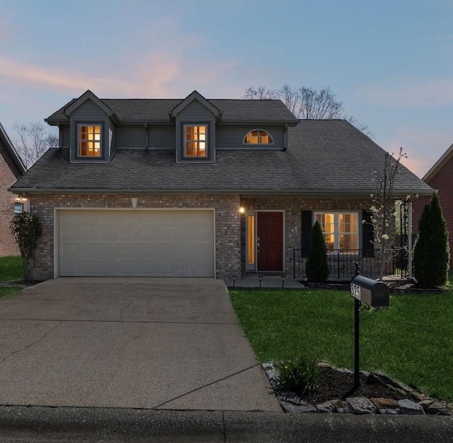 traditional home with concrete driveway, a front yard, brick siding, and a garage