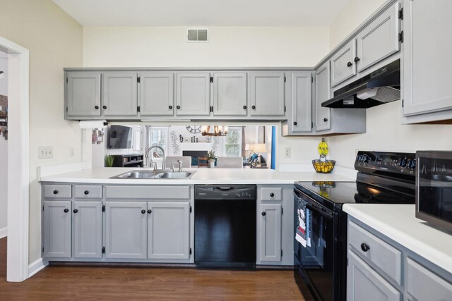 kitchen featuring visible vents, a sink, under cabinet range hood, black appliances, and gray cabinetry