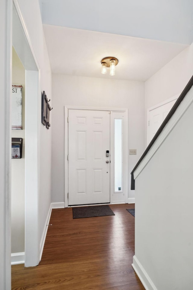 foyer entrance with baseboards, stairway, and dark wood finished floors