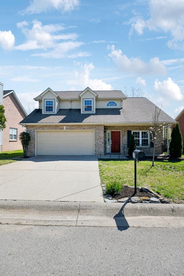 traditional-style home featuring driveway, a garage, a front lawn, and brick siding