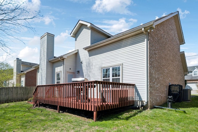 back of house with a yard, fence, a deck, and a chimney