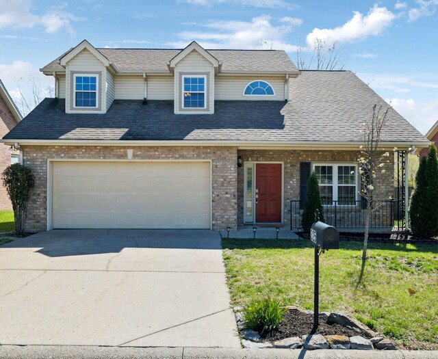 traditional home featuring concrete driveway, a front lawn, and brick siding