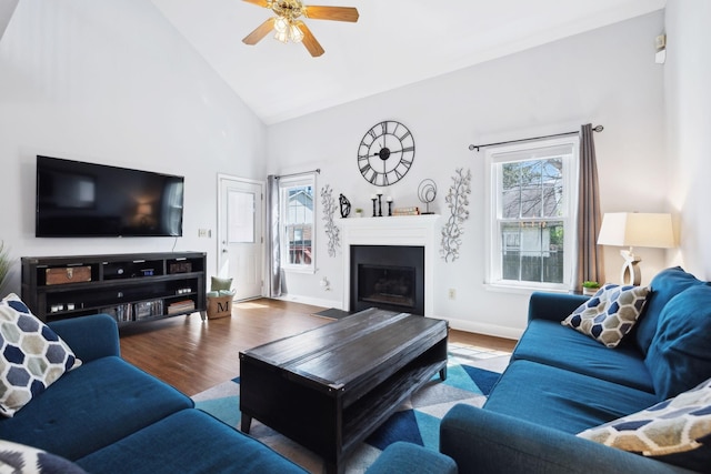 living room featuring baseboards, a fireplace, ceiling fan, high vaulted ceiling, and wood finished floors