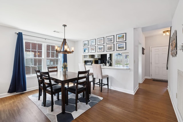 dining room with dark wood-style flooring, a wealth of natural light, an inviting chandelier, and baseboards