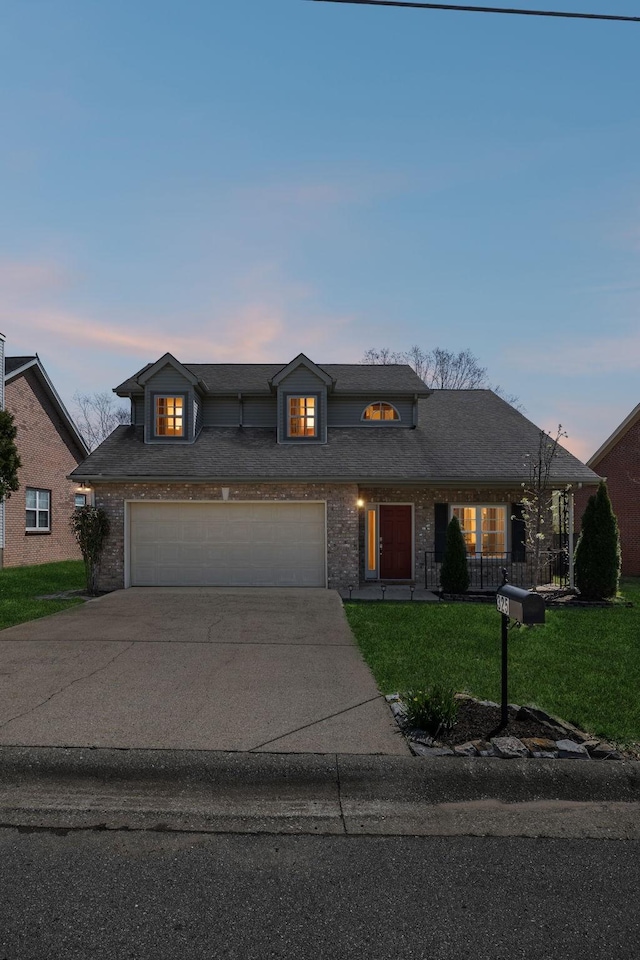 traditional-style house featuring brick siding, a front lawn, a garage, and driveway