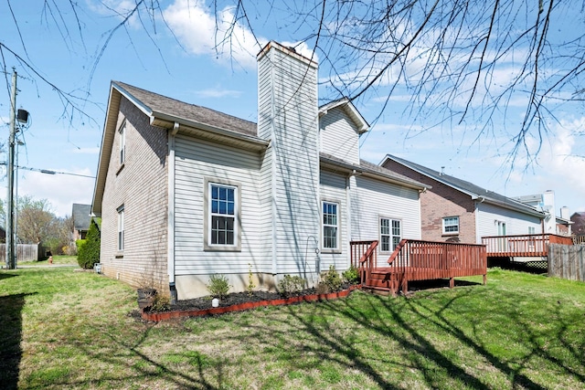 back of property featuring a yard, a deck, and a chimney