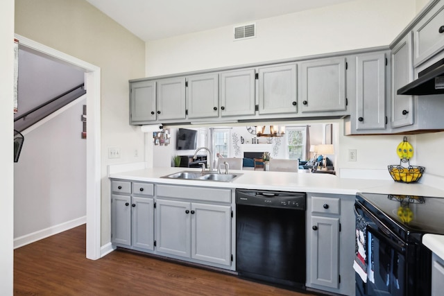 kitchen with gray cabinetry, dark wood-style flooring, a sink, and black appliances