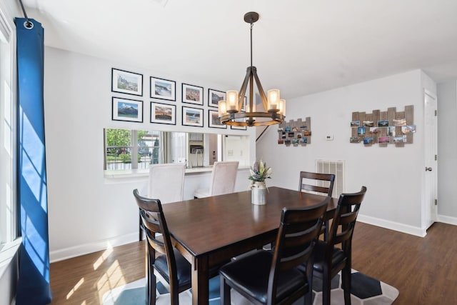 dining area with dark wood-style flooring, visible vents, baseboards, and an inviting chandelier