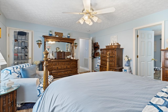 bedroom featuring visible vents, a textured ceiling, and ceiling fan