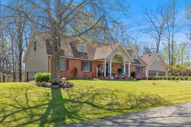 cape cod-style house featuring a front yard, brick siding, fence, and covered porch