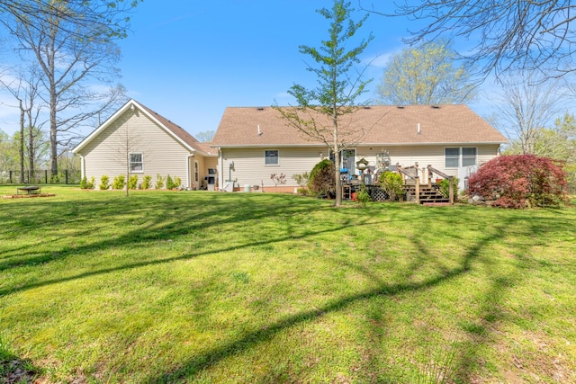 back of property with a deck and a lawn