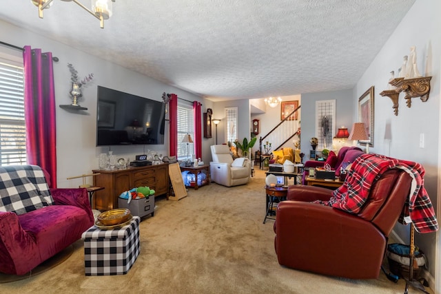 carpeted living room featuring stairway, an inviting chandelier, and a textured ceiling