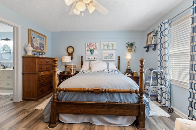 bedroom featuring ceiling fan, wood finished floors, and a textured ceiling
