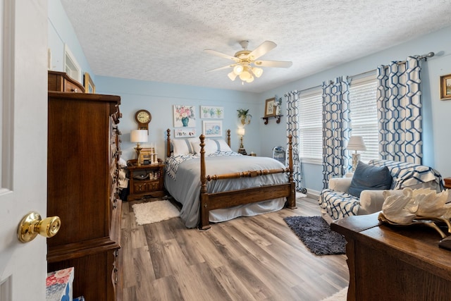 bedroom with a textured ceiling, wood finished floors, and ceiling fan
