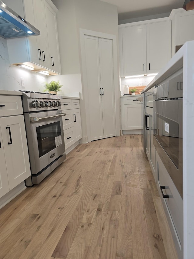 6376A Ivy St, Nashville, TN 37209 - kitchen with white cabinetry, range hood, light wood-style floors, and high end stainless steel range oven