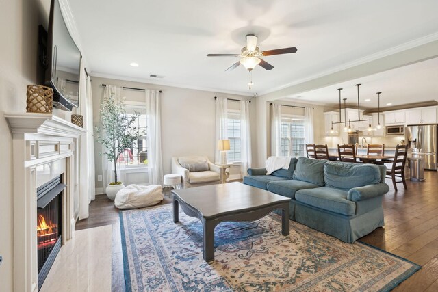 7025 Headwaters Dr, Franklin, TN 37064 - living room with ornamental molding, ceiling fan, wood finished floors, and a fireplace