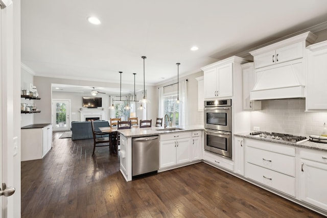 7025 Headwaters Dr, Franklin, TN 37064 - kitchen featuring a peninsula, ornamental molding, a sink, stainless steel appliances, and open floor plan