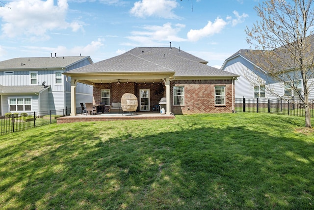 7025 Headwaters Dr, Franklin, TN 37064 - back of property featuring a yard, a fenced backyard, a patio, roof with shingles, and brick siding