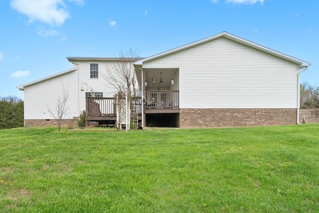 rear view of property with a yard, crawl space, and a wooden deck