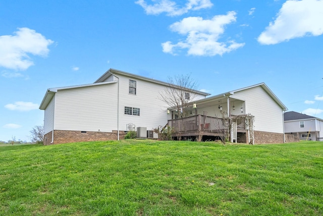 rear view of house with cooling unit, a yard, a deck, and crawl space
