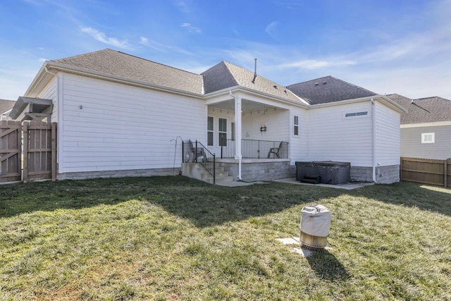 back of house with fence private yard, a patio area, a hot tub, a yard, and a shingled roof