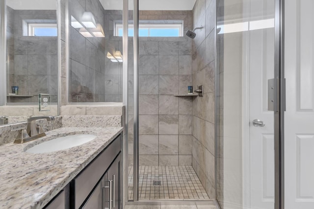 full bathroom featuring a stall shower, vanity, and a wealth of natural light