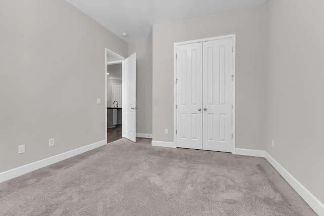 unfurnished bedroom featuring a closet, carpet flooring, and baseboards