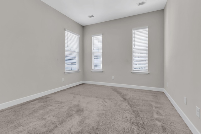 unfurnished room with baseboards, visible vents, and carpet floors