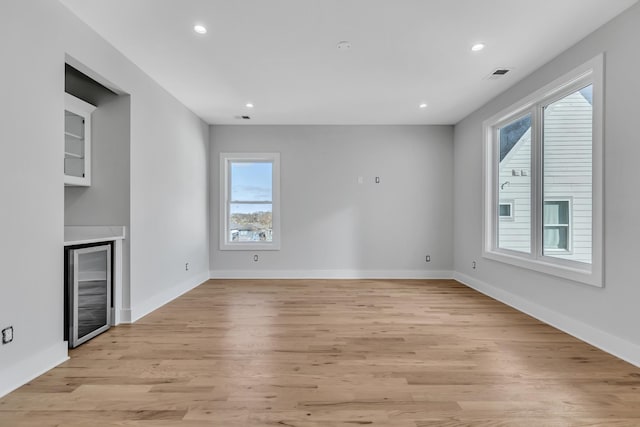 6376B Ivy St, Nashville, TN 37209 - unfurnished living room featuring wine cooler, light wood-style floors, visible vents, and a wealth of natural light