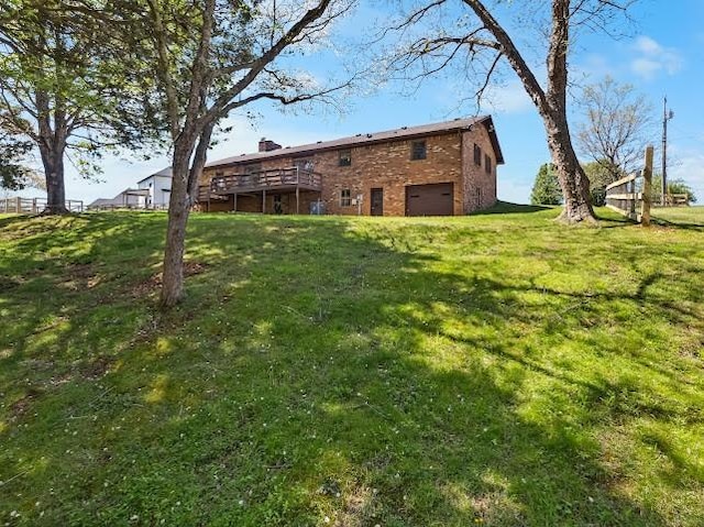 view of yard featuring a wooden deck and a garage