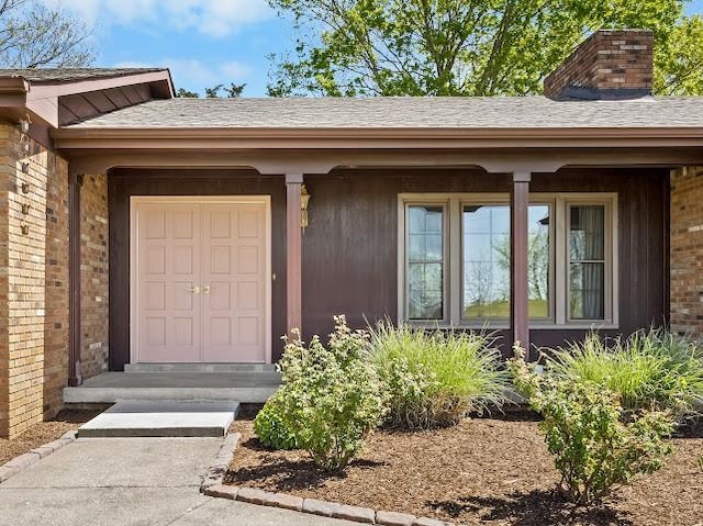 property entrance featuring brick siding and a chimney
