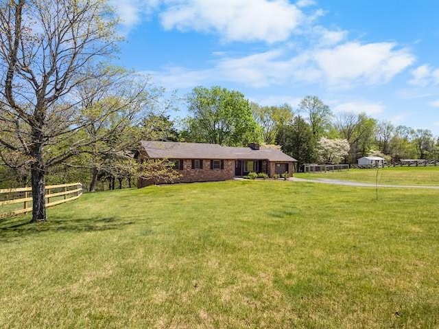 view of front of home with driveway, a front lawn, fence, and an attached garage