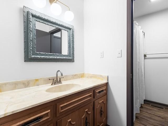bathroom featuring visible vents, vanity, and wood finished floors
