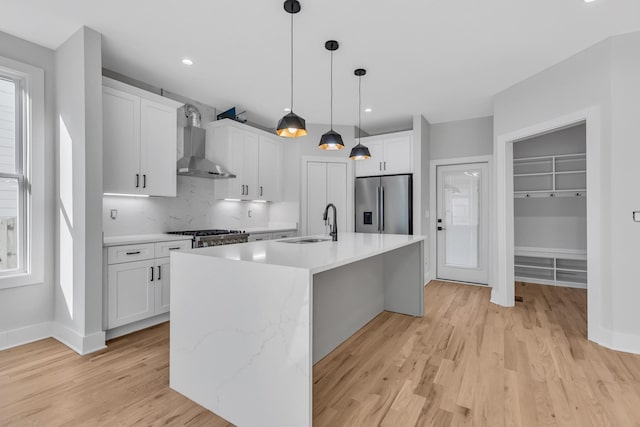 6376D Ivy St, Nashville, TN 37209 - kitchen featuring stainless steel fridge, light wood-style flooring, light countertops, wall chimney exhaust hood, and a sink
