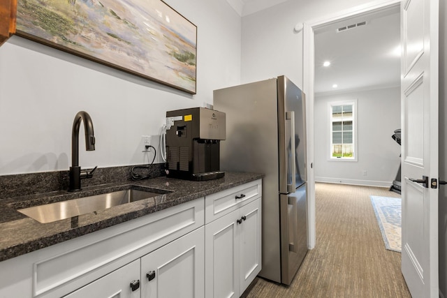 113 Cheekwood Ter, Nashville, TN 37205 - kitchen featuring dark stone counters, white cabinets, carpet flooring, a sink, and crown molding