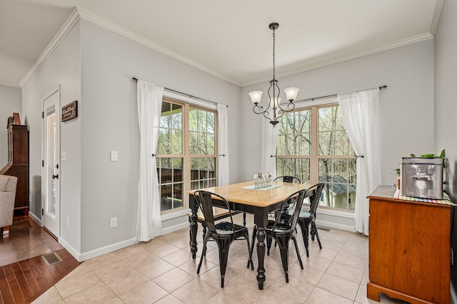 dining area featuring visible vents, baseboards, light tile patterned floors, ornamental molding, and a chandelier