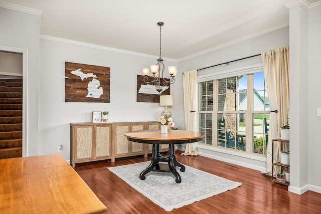 dining space with ornamental molding, dark wood finished floors, a chandelier, and stairs
