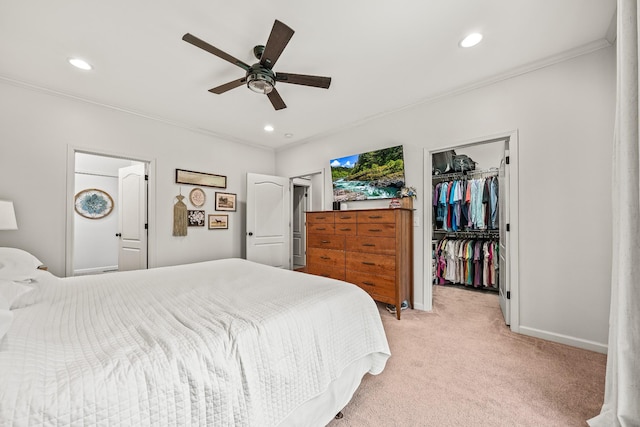 bedroom with a spacious closet, light carpet, crown molding, and a closet