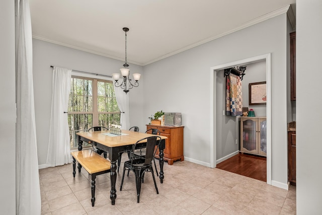dining area with a chandelier, baseboards, and ornamental molding