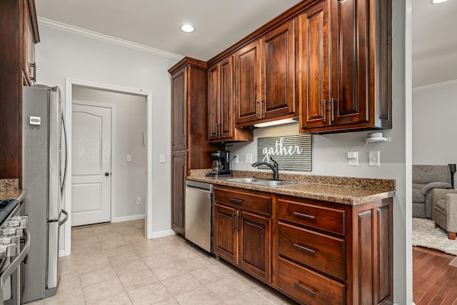 kitchen with baseboards, a sink, crown molding, recessed lighting, and stainless steel appliances